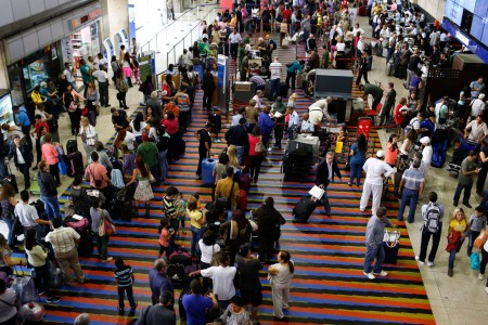 Passengers line up for the security checkpoint at Simon Bolivar airport in La Guaira